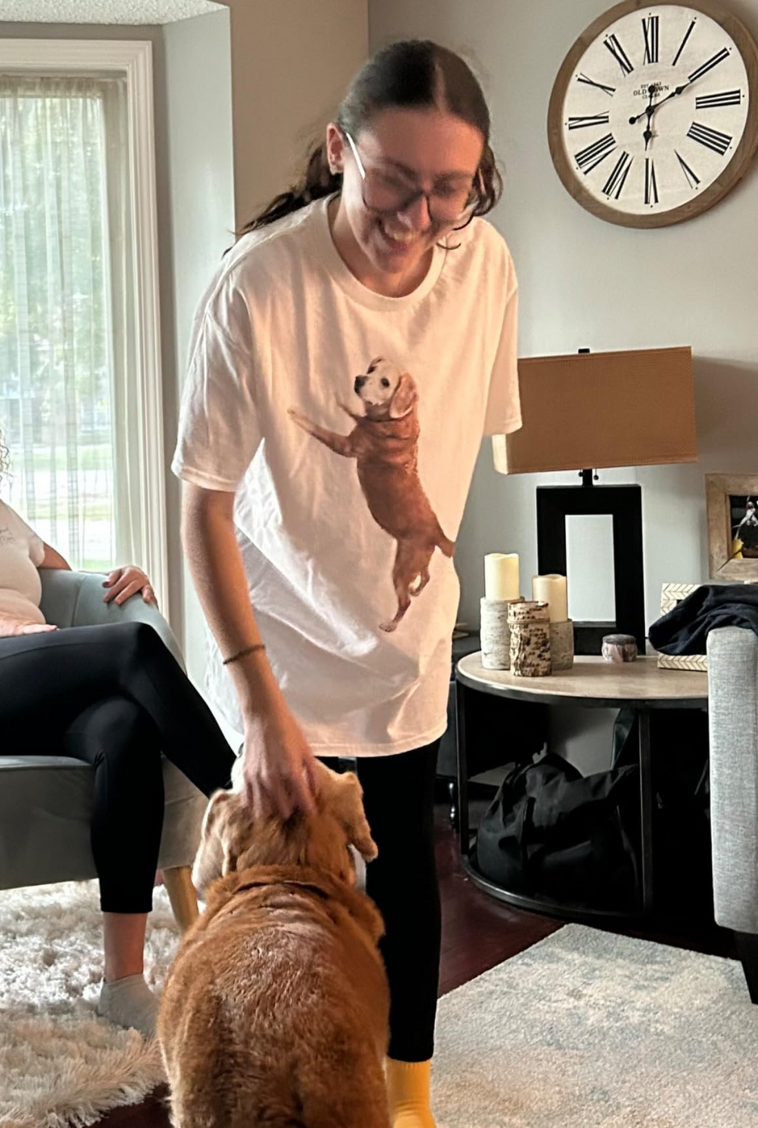 Woman wearing a white custom pet photo T-shirt while petting a dog